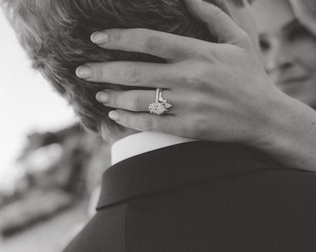 Engaged couple embracing, showing engagement ring, beginning wedding planning with calm and clarity